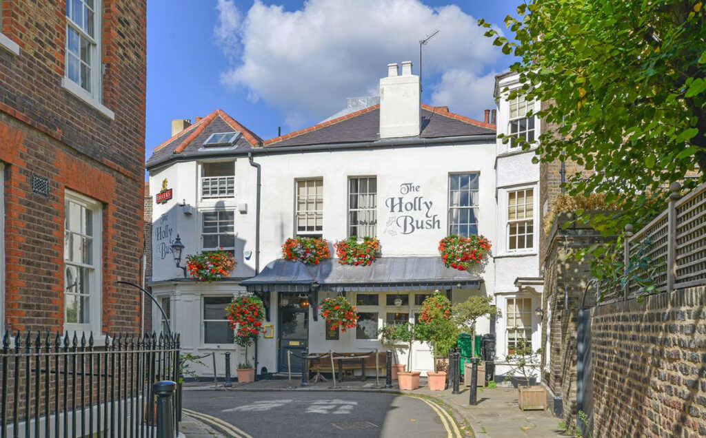 Whitewashed traditional pub with hanging baskets with red flowers