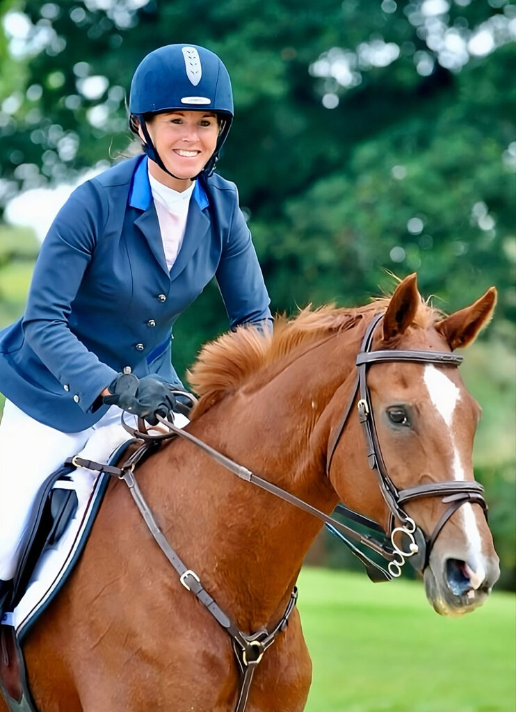 Katherine Watters smiling after competing on a brown horse