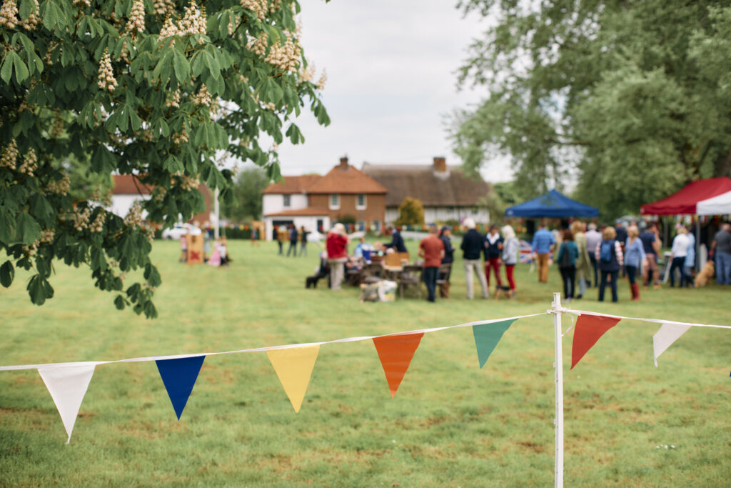 UK, Hertfordshire, Perry Green, close up of Bunting hanging in front of outdoor celebrations in a field